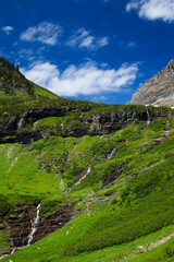 Green grass and waterfalls along the Going to the Sun Road in Glacier National Park, Montana, USA