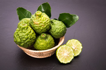 Bergamot, kaffir lime and kaffir lime leaf with basket on dark background