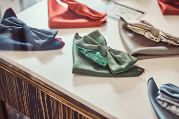 Close-up photo of a silk bow ties different colors on table in a menswear store.
