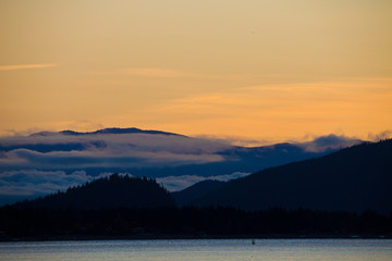 Fototapeta na wymiar Silhouetted hills around Shuswap Lake and colorful orange sky, British Columbia, Canada
