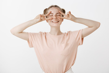 Girl open for new incredible adventures. Happy optimistic cute european female with stylish buns...