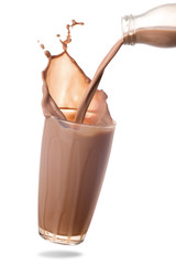 Pouring chocolate milk from bottle into glass with splashing isolated on white background.