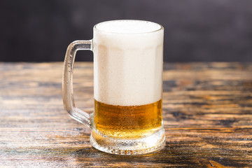 Glass of beer on wooden table. A mug of beer
