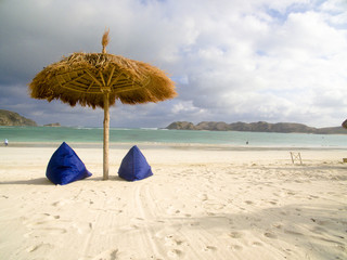 Fototapeta na wymiar Gili Trawangan is a tropical sea. View of nice tropical empty sandy beach with umbrella and beach chair, turquoise water