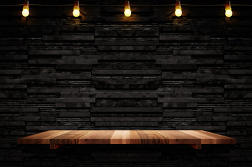 Empty brown plank wood shelf at black layer marble tile wall background,Mock up for display or...