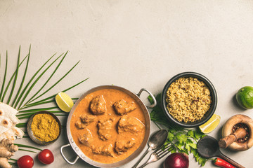 Traditional curry and ingredients on concrete background