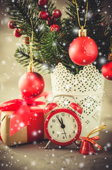 Fototapeta na wymiar Christmas composition: xmas fir branches, alarm clock, gift box and decorations.