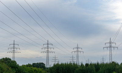 power transmission line pylons with threatening dark clouds background