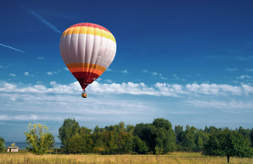 hot air balloon in blue cloudy sky