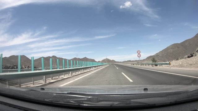 Driving car on Highway in gobi desert ,POV front windshield