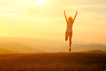 Happy woman with open arms stay on the peak of the mountain 