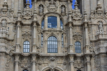 Fototapeta na wymiar Cathedral, Santiago de Compostela, Spain. Baroque facade closeup with windows and clouds reflections.
