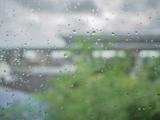 Raindrop on the window with blur photo of tree and the sky