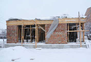 House construction site in winter. Building house construction during winter months.
