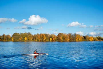 Side view of young man kayaking on Daugava river in sunny autumn day. Scenic View