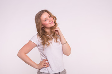 Young smiling woman posing over white background with copy space
