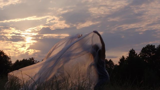 Slow Motion Shot Of A Woman Dancing With Plastic At Sunset In A Natural Environment
