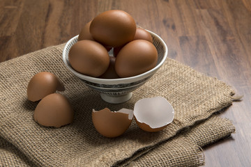Fresh chicken eggs in bowl on sackcloth and egg shell