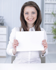 business woman showing blank sheet,sitting behind a Desk