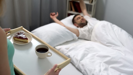 Lady carrying tray with breakfast for boyfriend, pleasant surprise for beloved