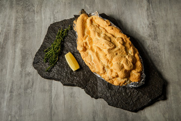 baked dorado under egg whites served with sliced lemon and rosemary