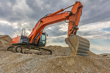 Excavators and heavy machinery in the works of stone movement in a quarry stone extraction for its...