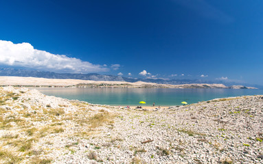 Beautiful Pag croatian beach and mountains in the background