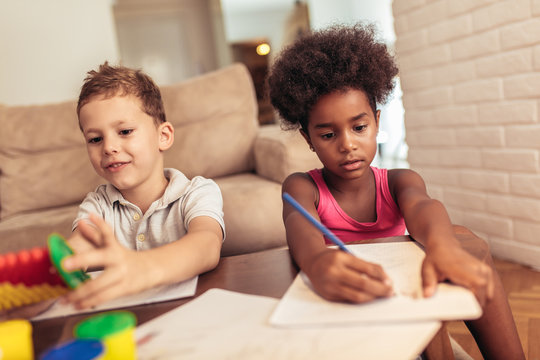 Multiracial children drawing using abacus at home