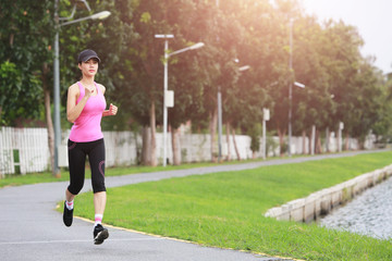 Sporty female jogger morning exercise on seaside in the park.