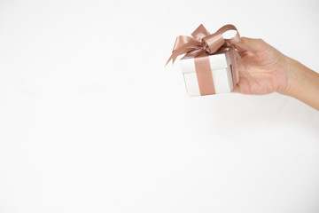 A female hand holding or giving a gift box in an isolated white background.