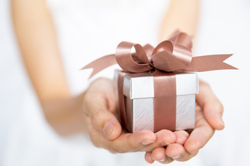 Closeup of woman hands holding a small gift box for special event.