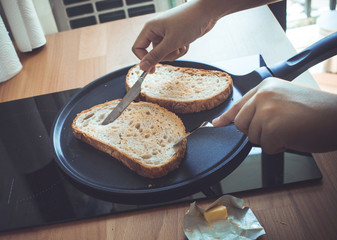 Young woman cooking (bread) breakfast on counter bar kitchen in the morning. healthy life concept