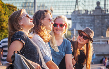 Group of happy smiling carefree young stylish girls communicate against the background of the city, millennium concept, youth and students, tourism and vacations