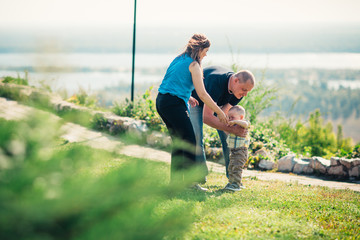 Happy family with baby son on nature background