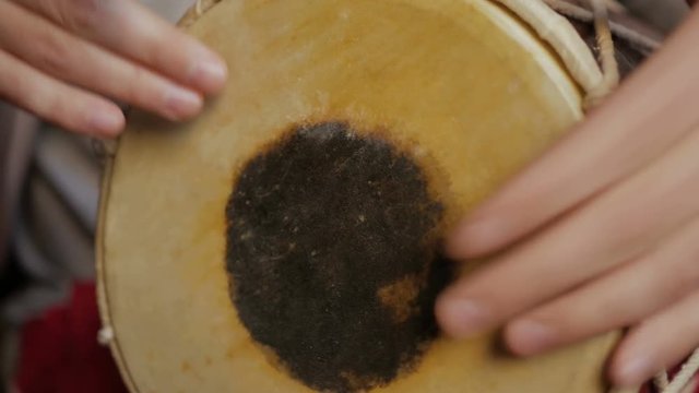 Close up of hands of a man playing a drum.