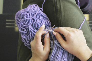 Knitting. Female hands with knitting needles. Top view. Close-up.