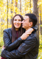 Fototapeta premium Cute couple outdoors in fall. Young man and woman in autumn nature