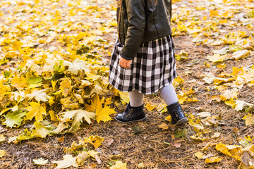 Legs of little girl in autumn background