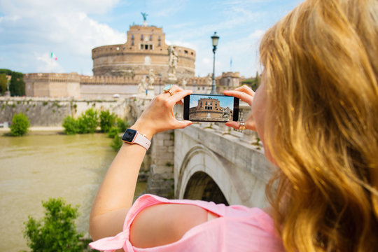 Woman taking photo of famous Castel Sant’Angelo in Rome, Italy