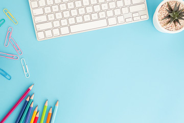 Flat lay photo of office desk with pencil and keyboard ,Top view workpace on blue background and...