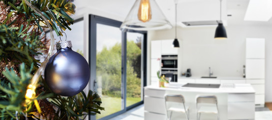 Open modern kitchen from loft with Merry Christmas tree