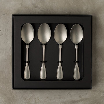 Top view of silver collection of tablespoons teaspoons in a black box on a gray concrete background