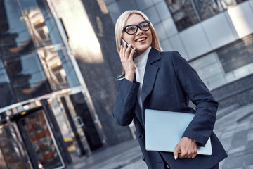 Successful business woman working at laptop in City