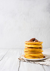 Stack of pancakes with pecan and syrup in nordic style