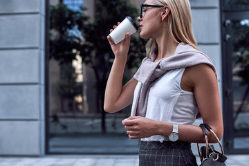 Young stylish woman drinks coffe. Close up view