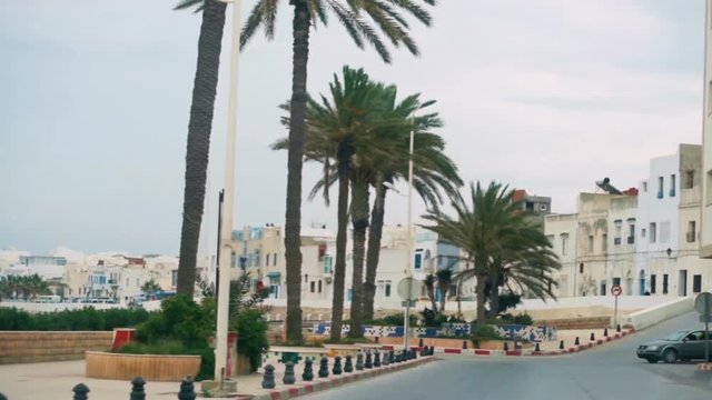 Car drive through central part of the ancient city of Mahdia in Tunisia. Driving along the embankment of the Mediterranean Sea in Tunisia. Along the road are date palms.  Tunisia, Mahdia - May 2018