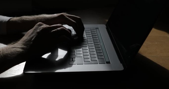Man Hands Typing On Keyboard Of Modern Laptop On Wooden Table.