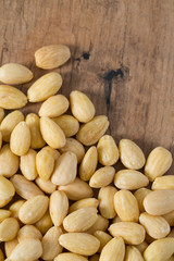 peeled almonds on wooden surface