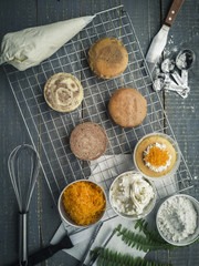 Cooling rack with delicious cupcakes on wooden background, top view.