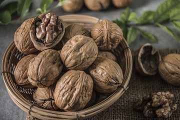 Walnuts in wooden bowl. Whole walnut on table